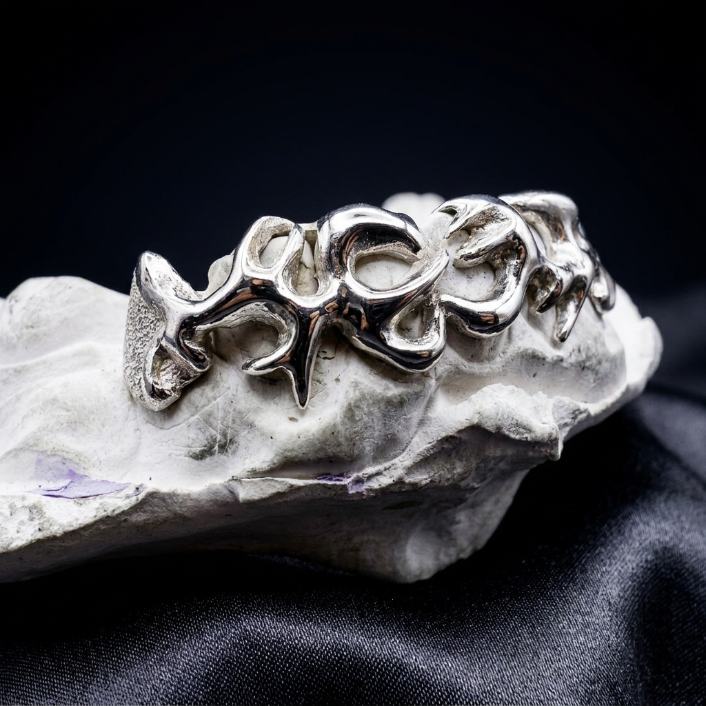 Polished 14K white gold custom "Mayson" script design grillz mounted on a dental plaster mold over black satin.