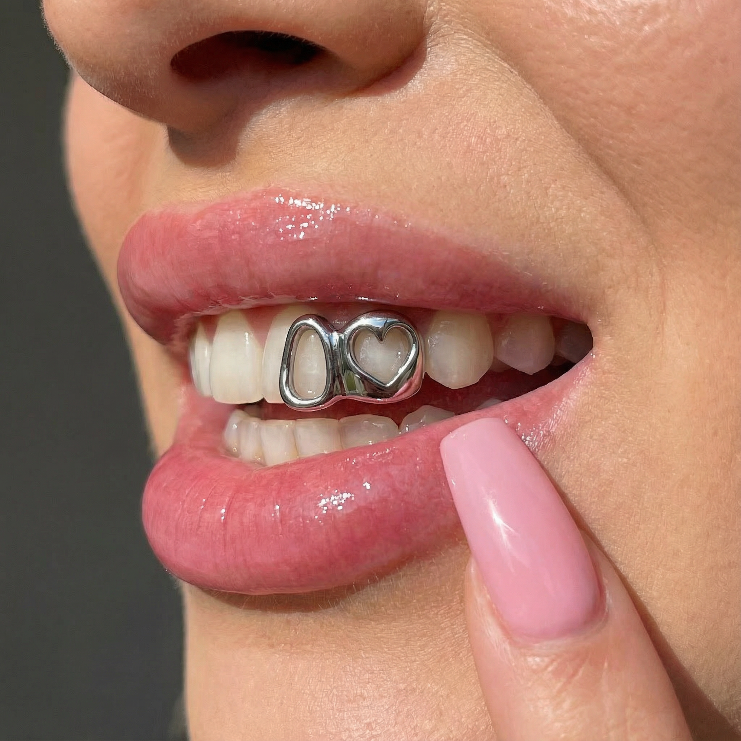 Custom silver heart grillz in models mouth