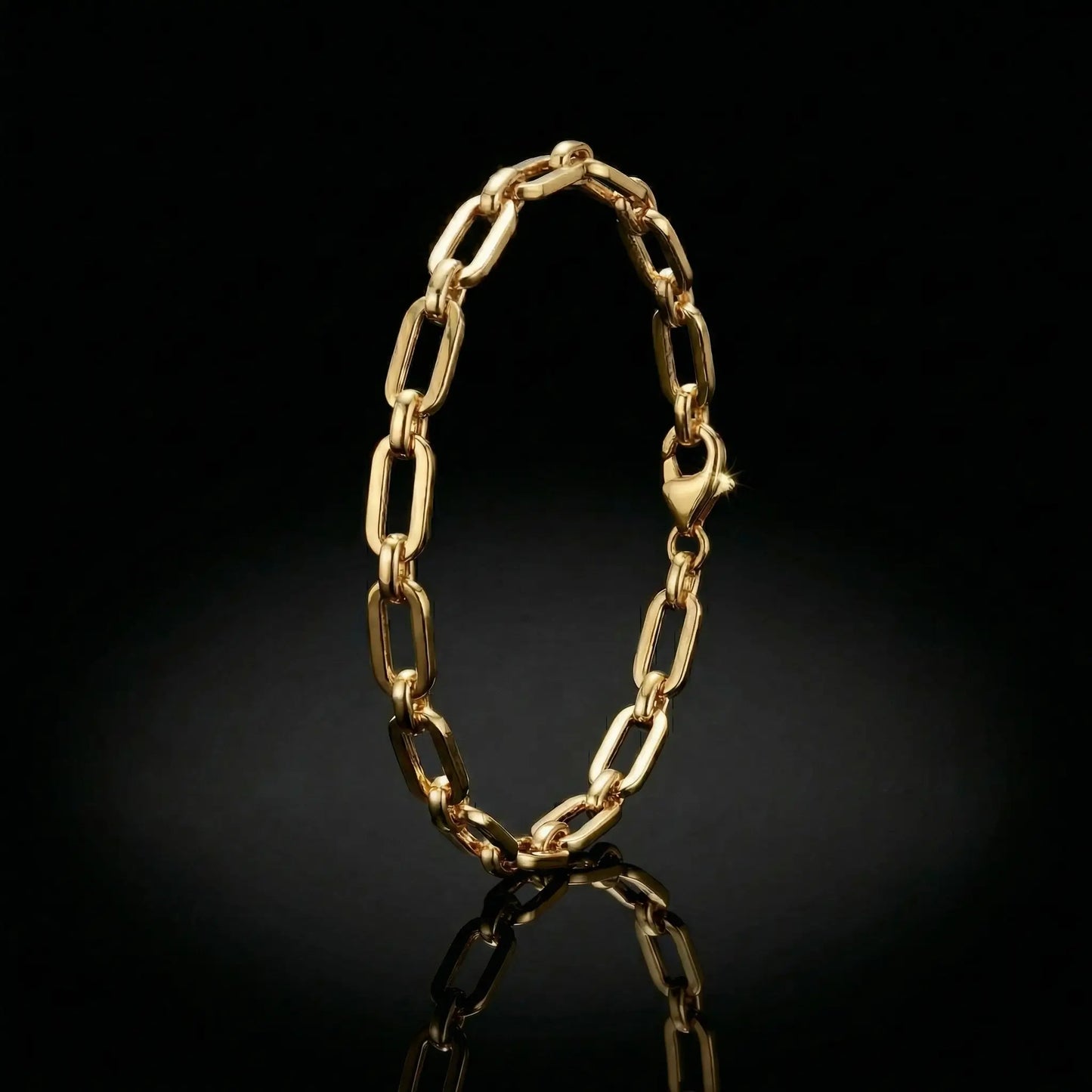 yellow golden womens paperclip bracelet laying on a mirrored surface.