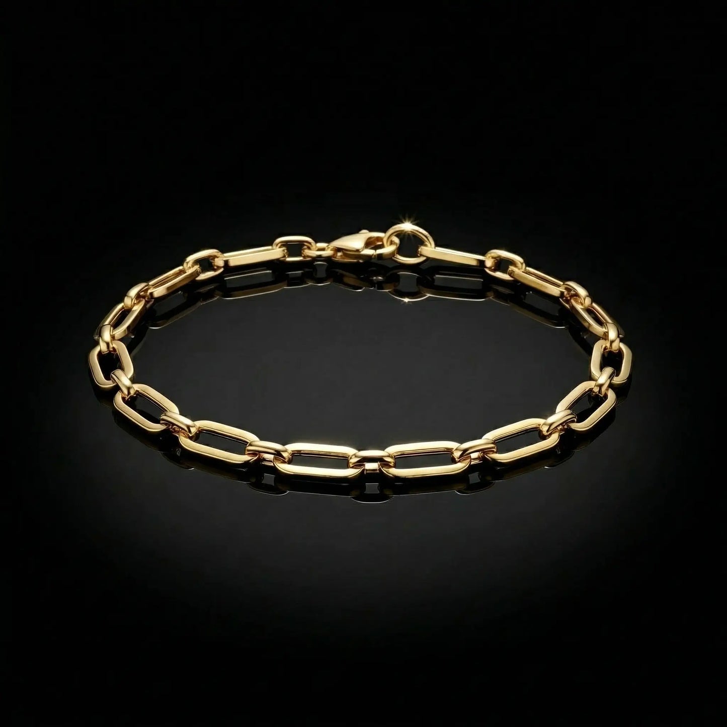 Yellow golden womens bracelet with paperclip links laying flat on a mirrored surface.