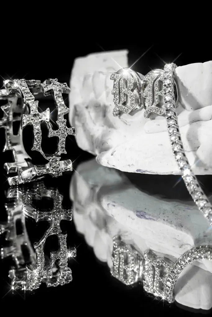 A Cross design diamond ring with a diamond grillz and tennis bracelet.