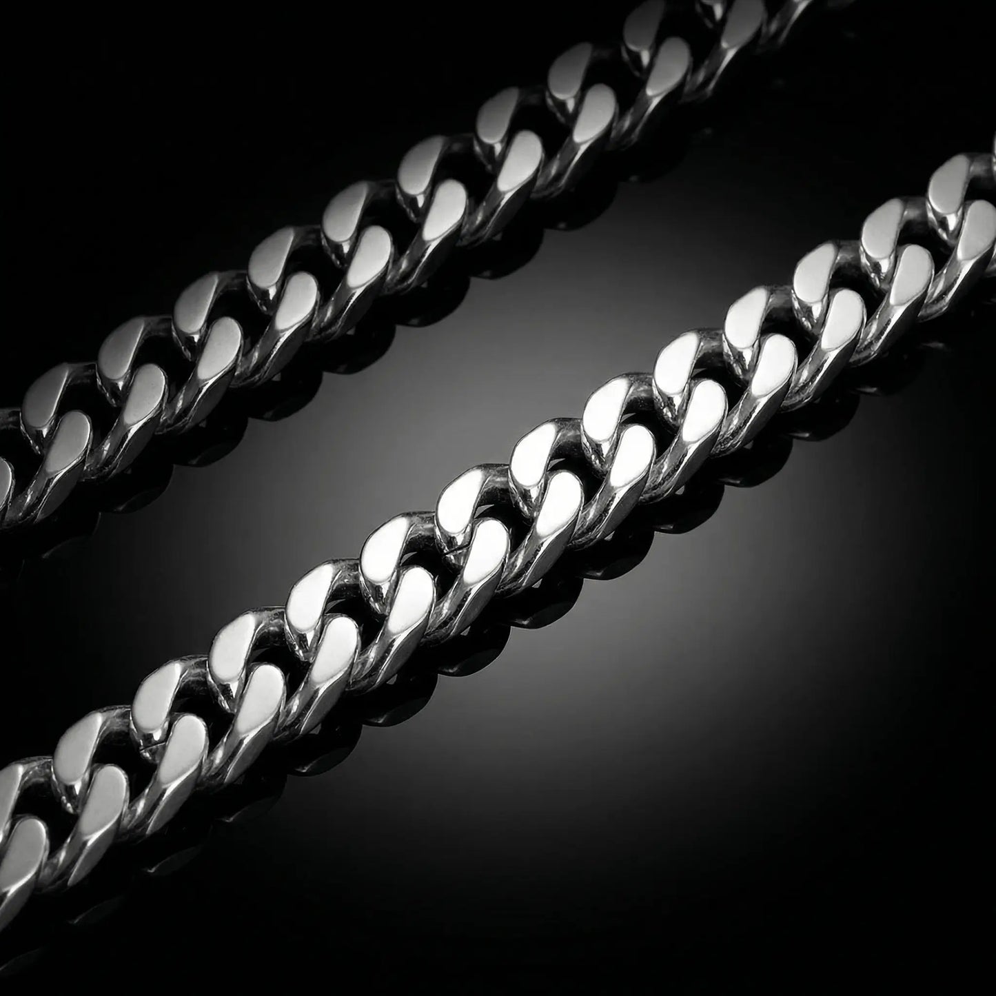 Silver mens chain laying flat on a mirrored surface. Cuban linksilver chain.