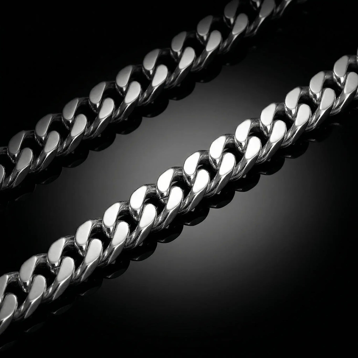 Silver mens chain laying flat on a mirrored surface. Cuban linksilver chain.