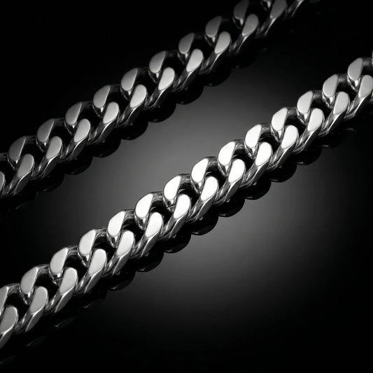 Silver mens chain laying flat on a mirrored surface. Cuban linksilver chain.